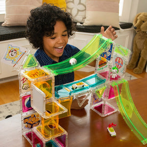 Boy rolling head down a build of Mega Set in a playroom