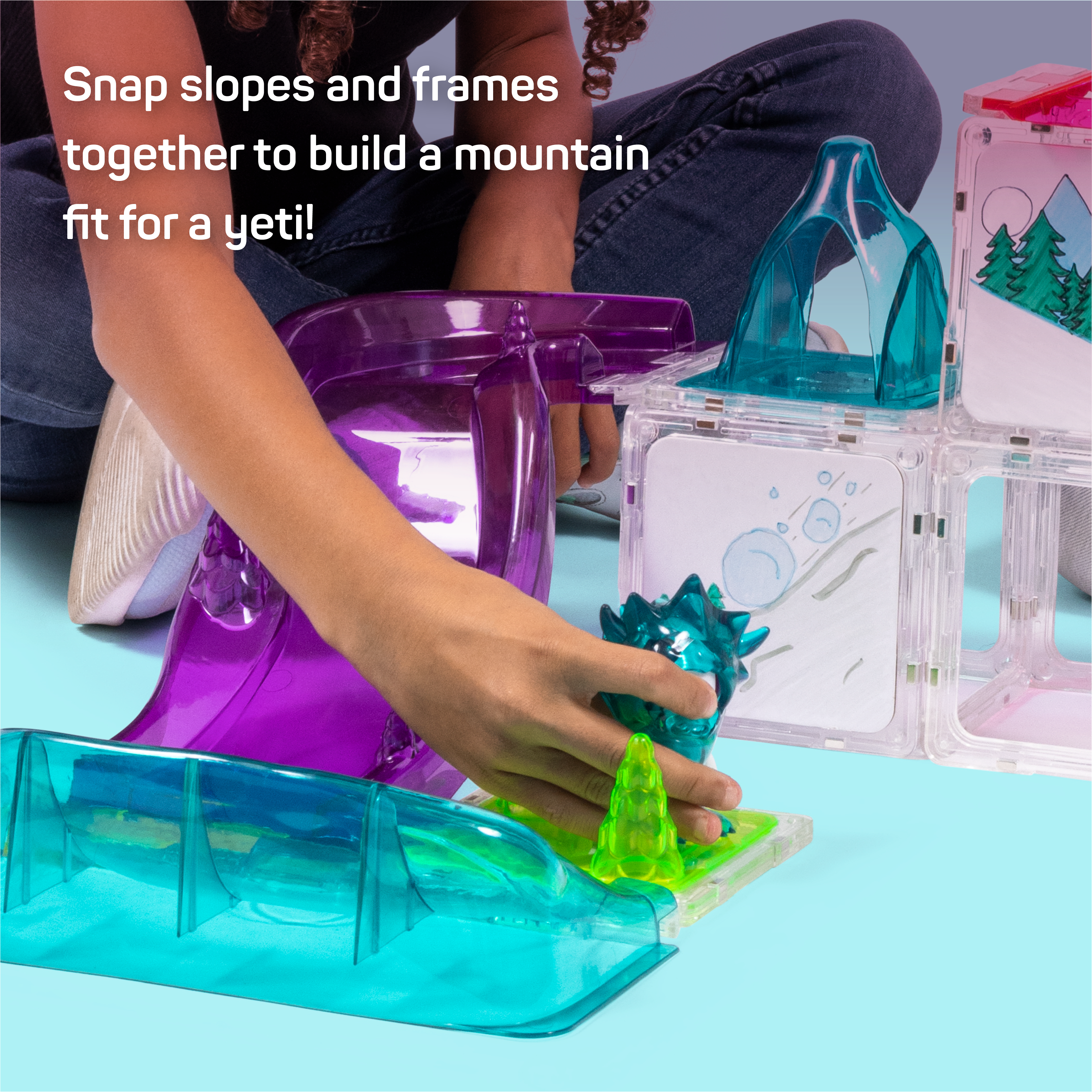 Kid playing with yeti character on Yeti Yikes build with text that reads "Snap slopes and frames together to build a mountain fit for a yeti!"