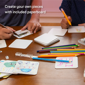 Two kids drawing on paperboard. Text which reads "Create your own pieces with included paperboard"
