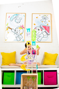Girl playing with a large tower of Squaregles with Oggs characters on the wall behind her